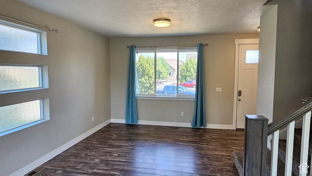 Entryway featuring dark wood-type flooring and a textured ceiling