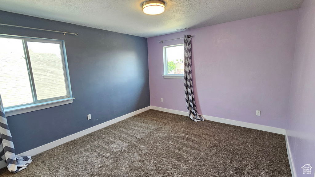 Carpeted spare room with a textured ceiling