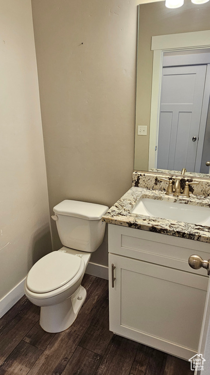 Bathroom with toilet, hardwood / wood-style floors, and vanity