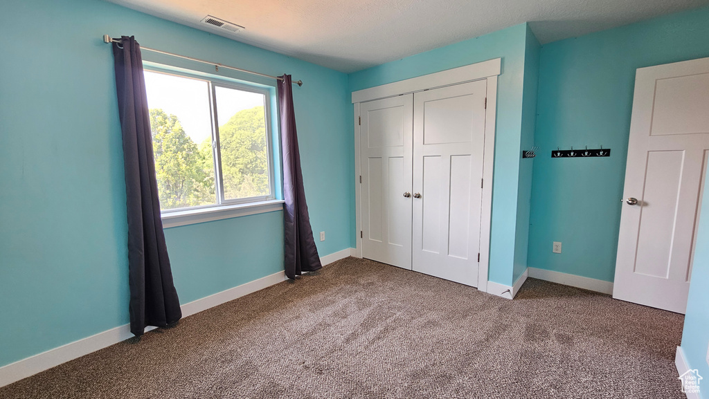 Unfurnished bedroom featuring a closet and carpet flooring