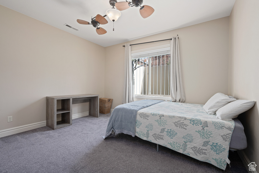 Carpeted bedroom featuring ceiling fan