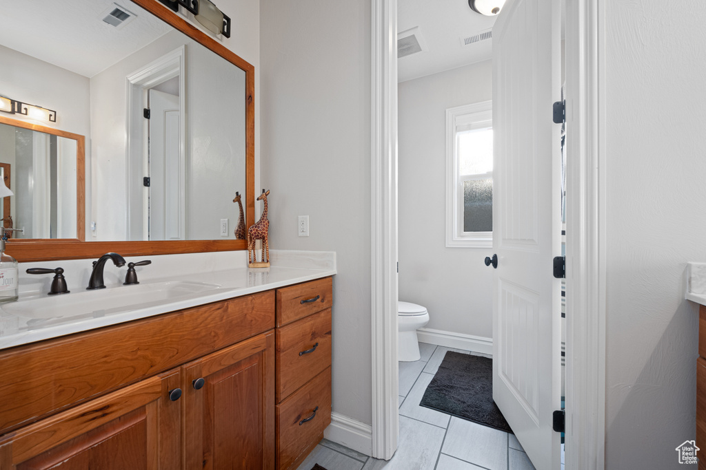 Bathroom featuring tile patterned floors, vanity, and toilet