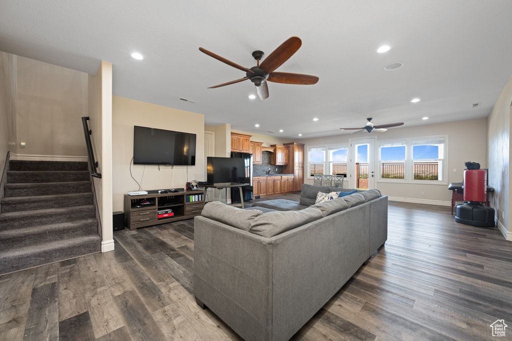 Living room with dark hardwood / wood-style floors and ceiling fan