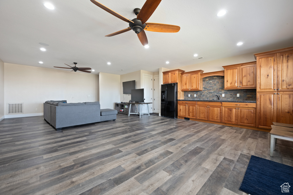 Kitchen with black refrigerator with ice dispenser, wood-type flooring, tasteful backsplash, and ceiling fan