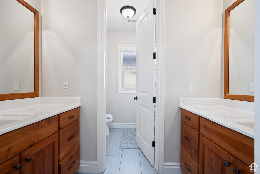 Bathroom featuring vanity, tile patterned floors, and toilet