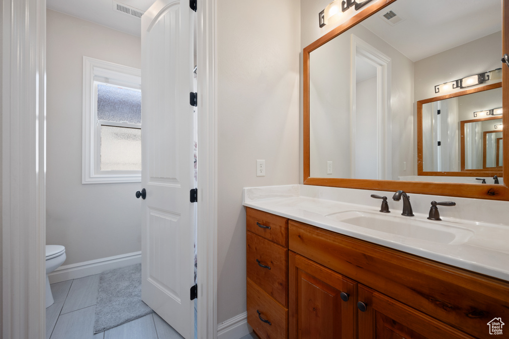 Bathroom featuring tile patterned floors, vanity, and toilet