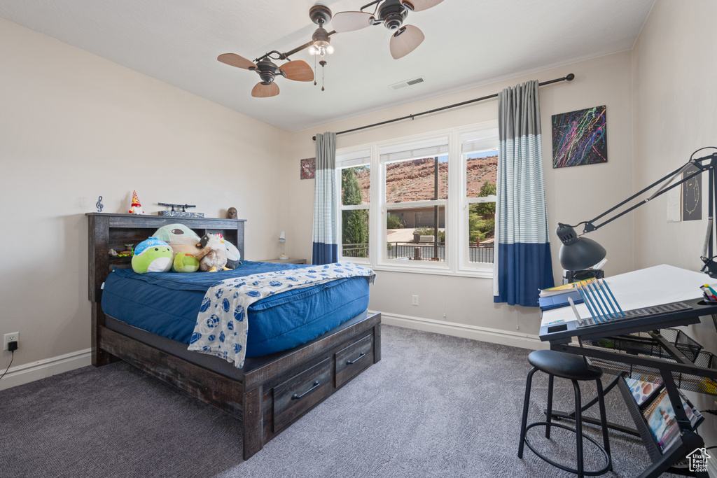 Carpeted bedroom featuring ceiling fan