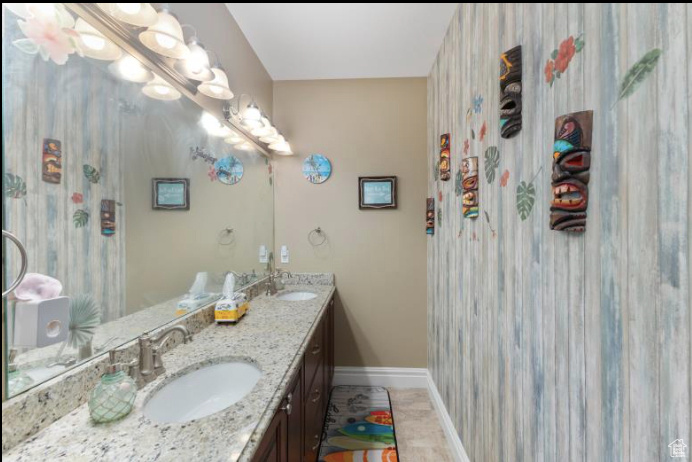 Bathroom featuring dual bowl vanity and tile patterned flooring