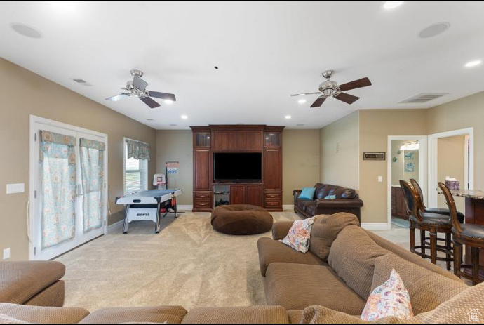 Living room with ceiling fan and light colored carpet