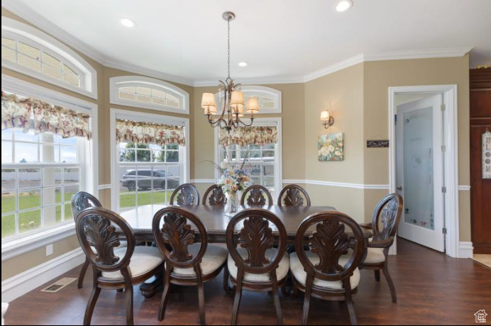 Dining room with crown molding, hardwood / wood-style flooring, and a chandelier