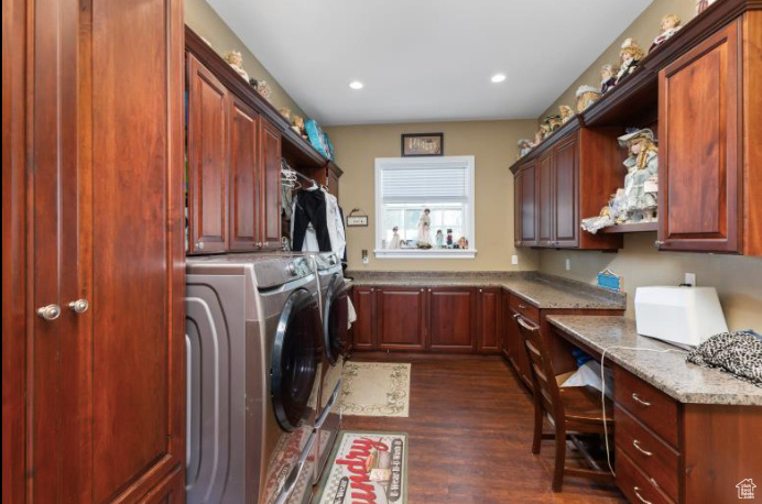 Laundry room featuring cabinets, washing machine and clothes dryer, and dark hardwood / wood-style flooring