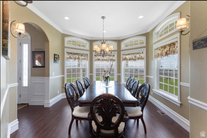 Dining room featuring an inviting chandelier, dark hardwood / wood-style flooring, and a healthy amount of sunlight