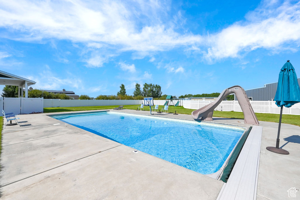 View of swimming pool featuring a patio and a water slide