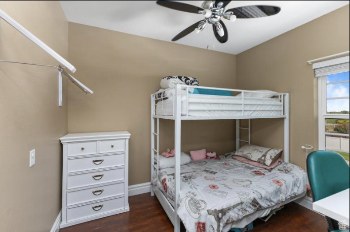 Bedroom with ceiling fan and dark hardwood / wood-style flooring