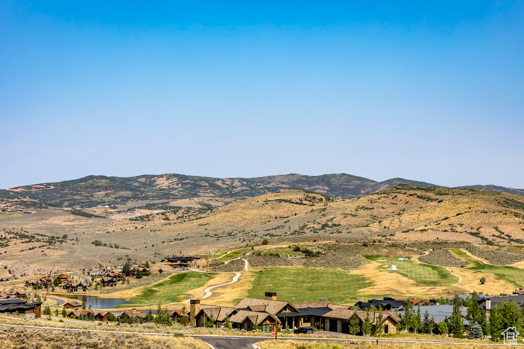 Property view of mountains with view of golf course and a water view
