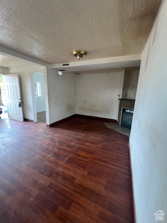 Empty room with wood-type flooring and a textured ceiling