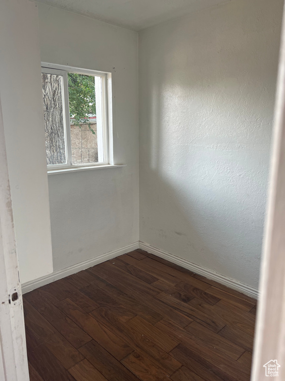 Empty room with dark wood-type flooring