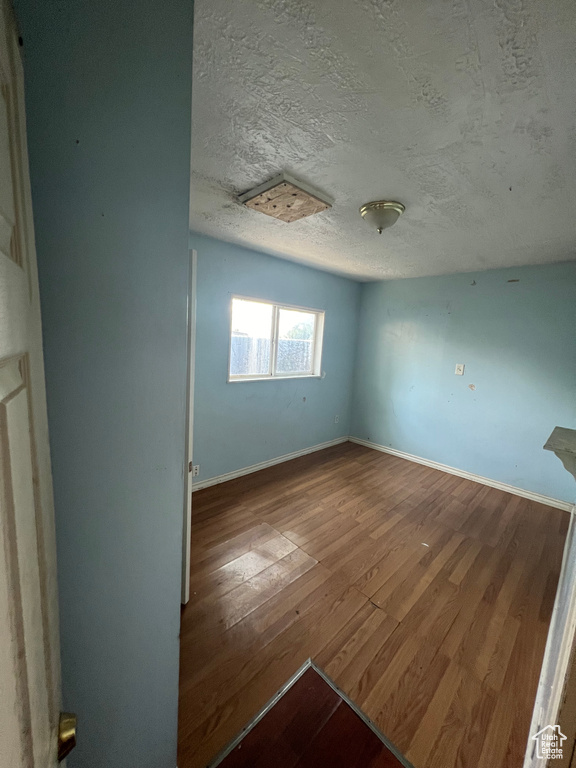 Unfurnished room featuring a textured ceiling and hardwood / wood-style flooring