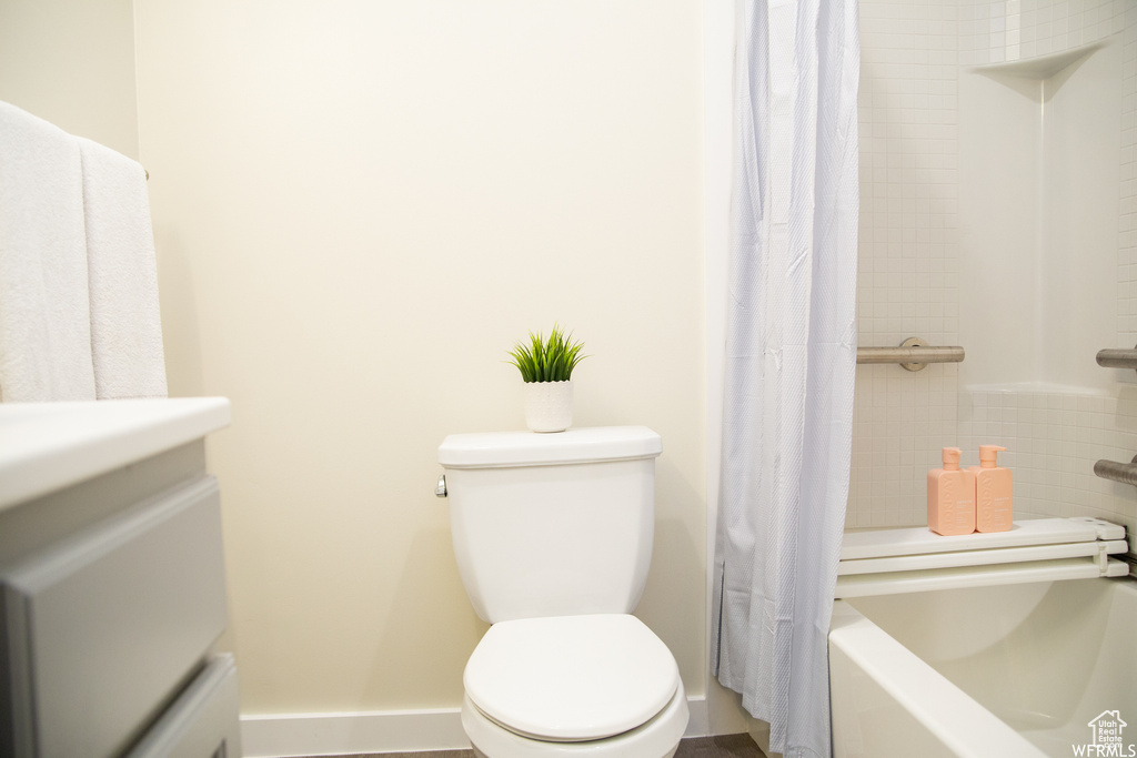 Full bathroom with vanity, shower / tub combo, and toilet