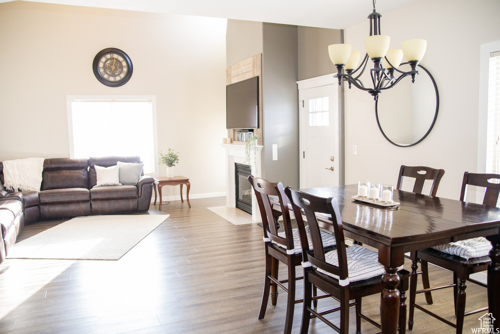 Dining room with light hardwood / wood-style floors and an inviting chandelier