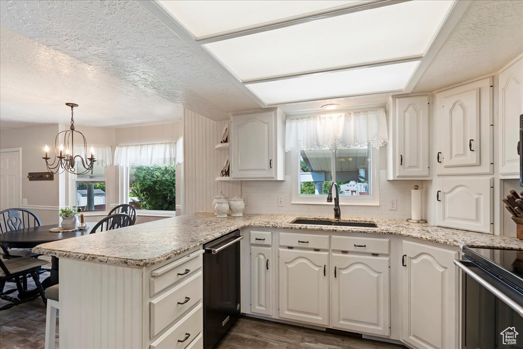 Kitchen featuring dark hardwood / wood-style floors, sink, kitchen peninsula, and a textured ceiling