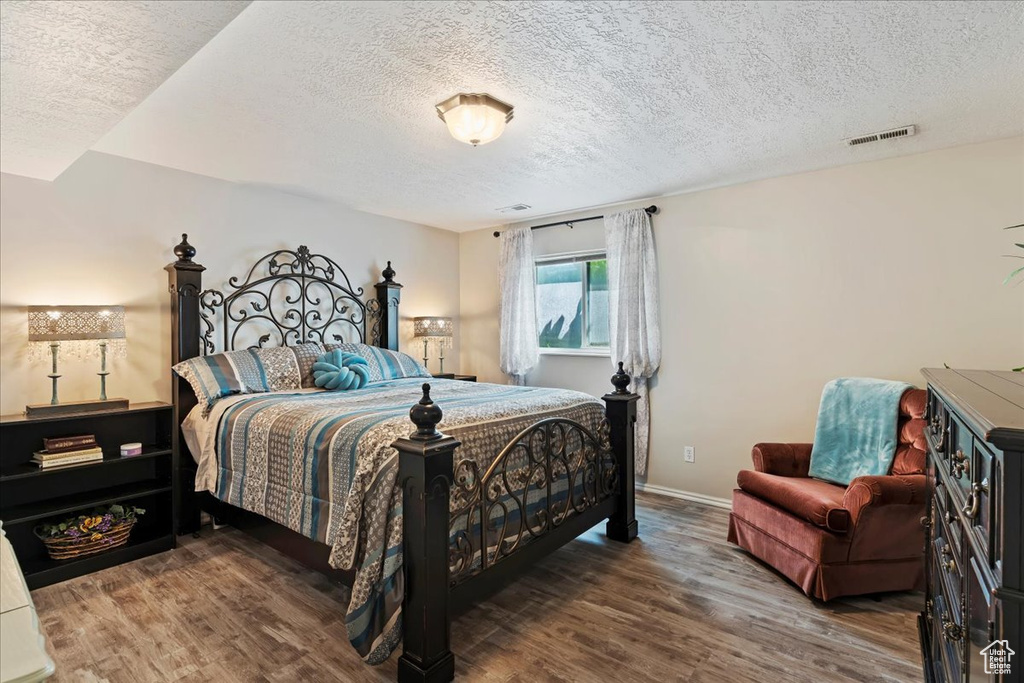 Bedroom featuring dark wood-type flooring and a textured ceiling