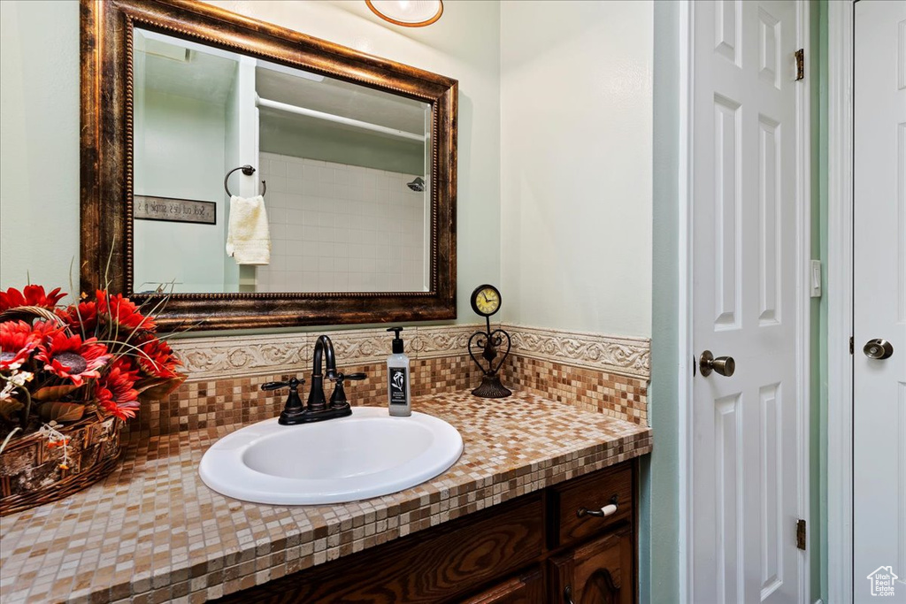 Bathroom featuring vanity and backsplash