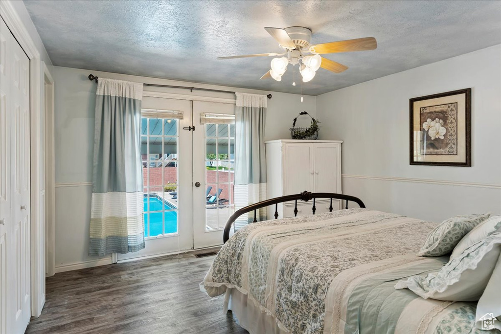 Bedroom with french doors, dark hardwood / wood-style flooring, access to exterior, ceiling fan, and a closet