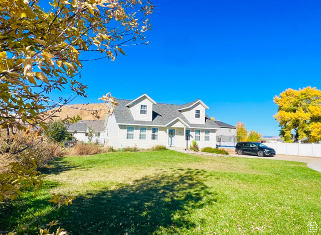 Cape cod-style house featuring a front yard