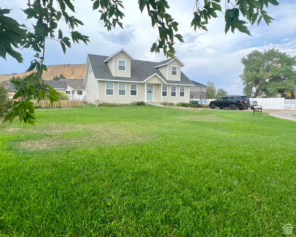 Cape cod-style house with a front yard