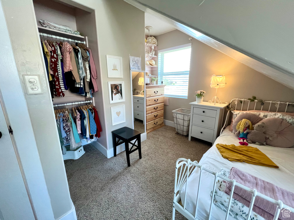 Bedroom with a closet, carpet, and lofted ceiling