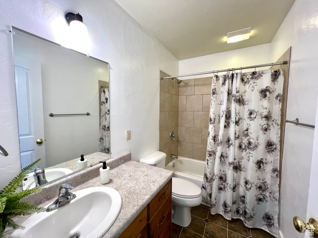 Full bathroom with vanity, shower / tub combo with curtain, toilet, and tile patterned floors