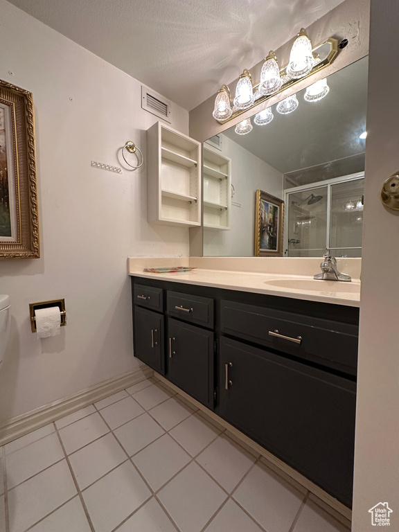 Bathroom with tile patterned floors, vanity, a textured ceiling, and toilet