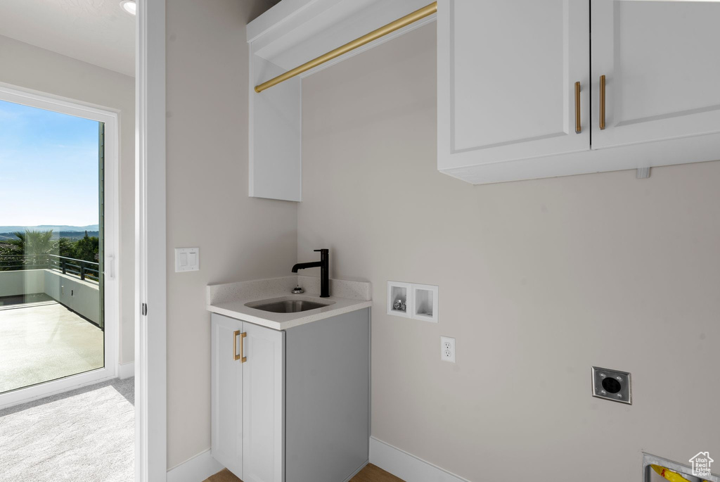 Washroom featuring washer hookup, hookup for an electric dryer, cabinets, and sink