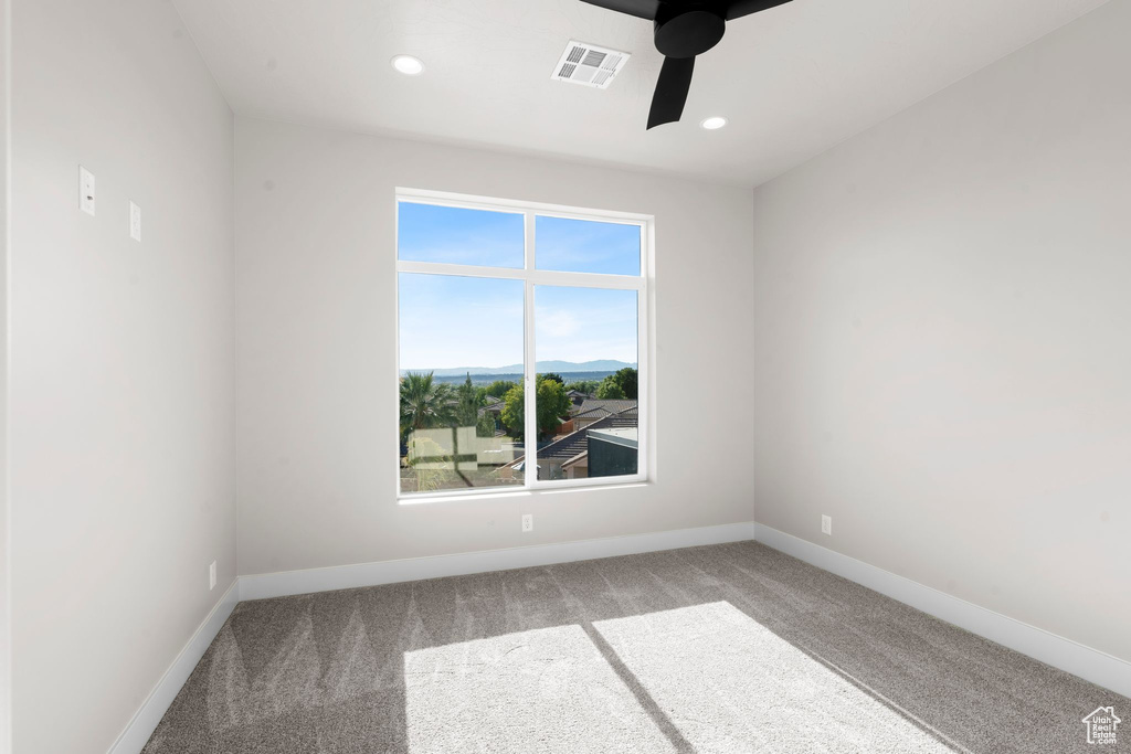 Carpeted empty room with ceiling fan