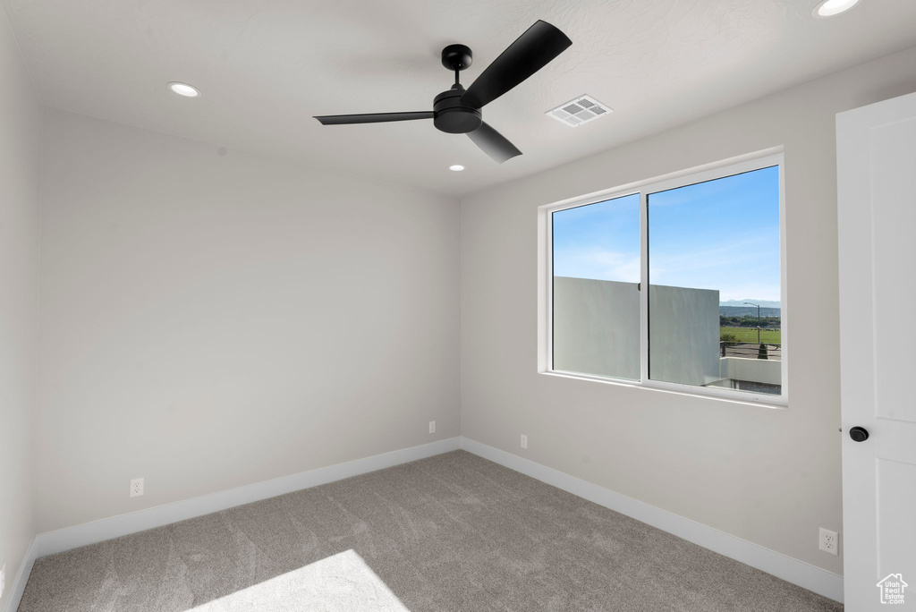 Empty room featuring carpet floors and ceiling fan