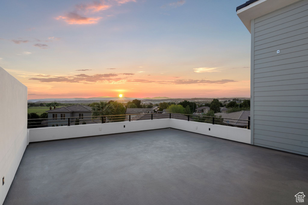 Patio terrace at dusk featuring a balcony