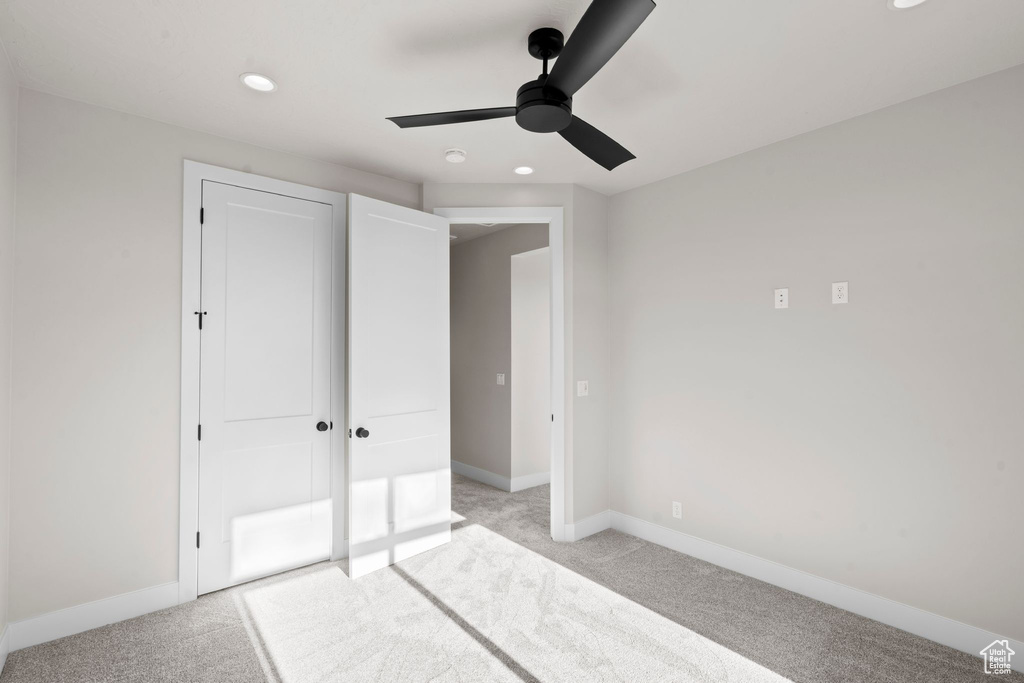 Unfurnished bedroom featuring ceiling fan and light carpet