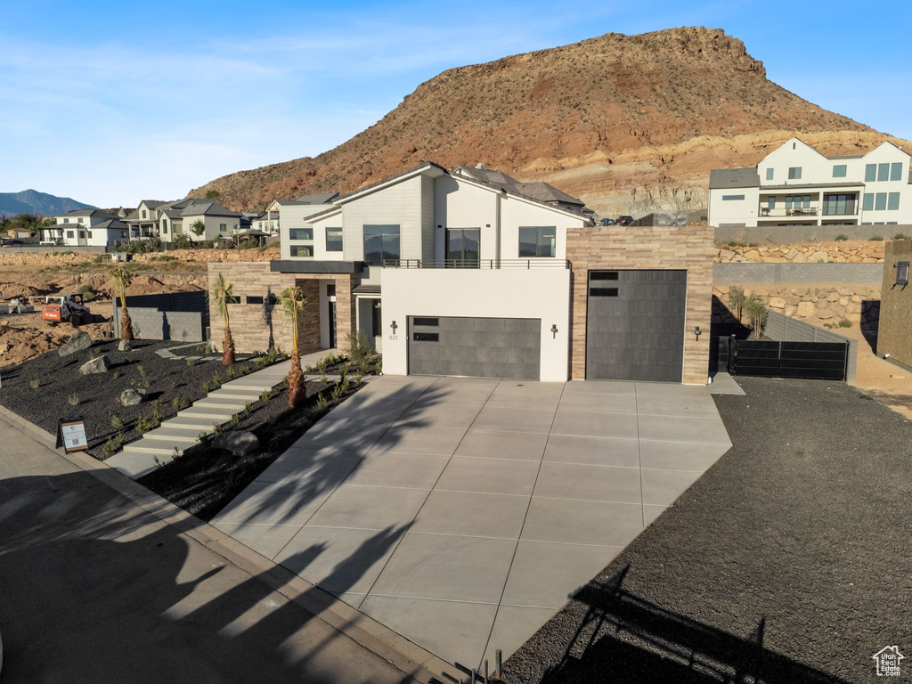 View of front of home with a mountain view and a garage