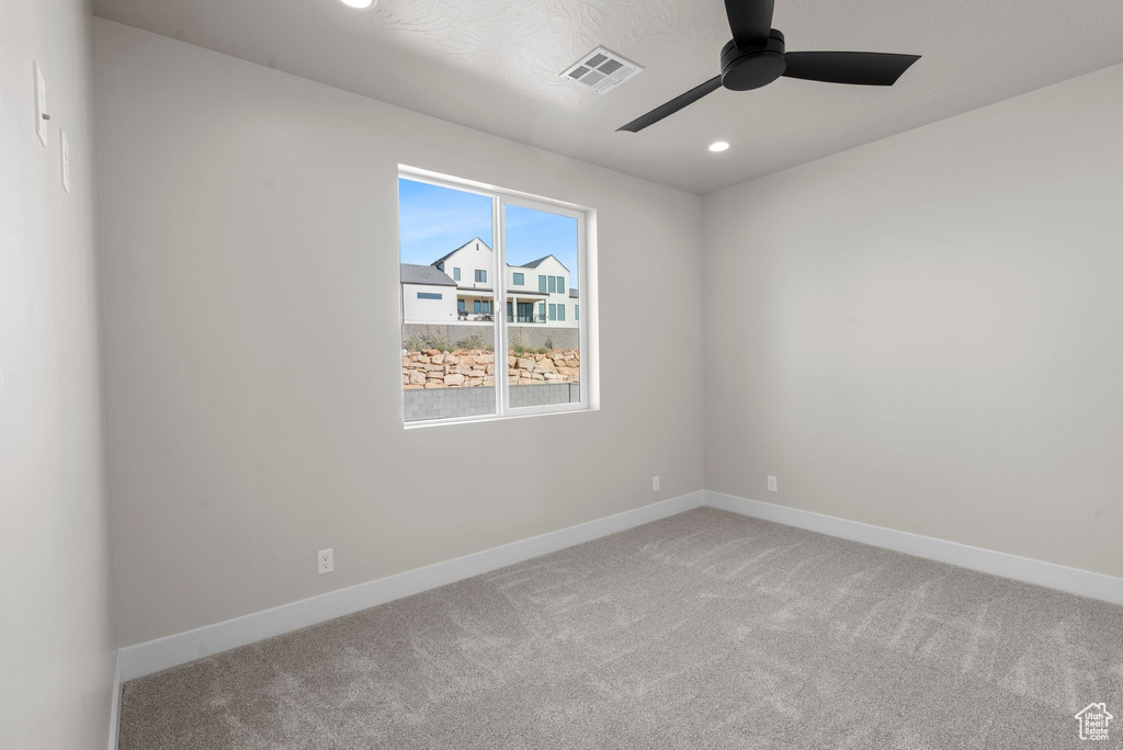 Unfurnished room featuring carpet and ceiling fan