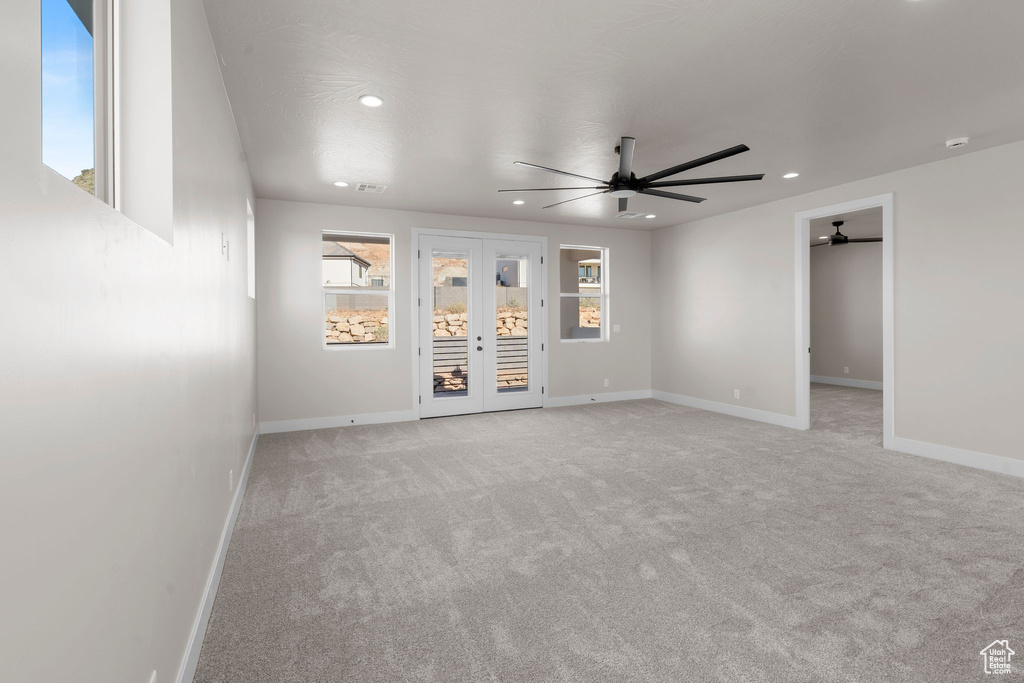 Unfurnished room with light carpet, french doors, and ceiling fan