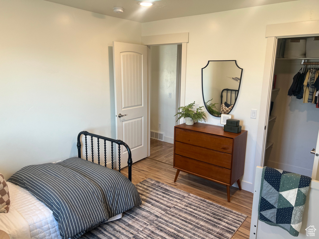 Bedroom with hardwood / wood-style flooring and a closet