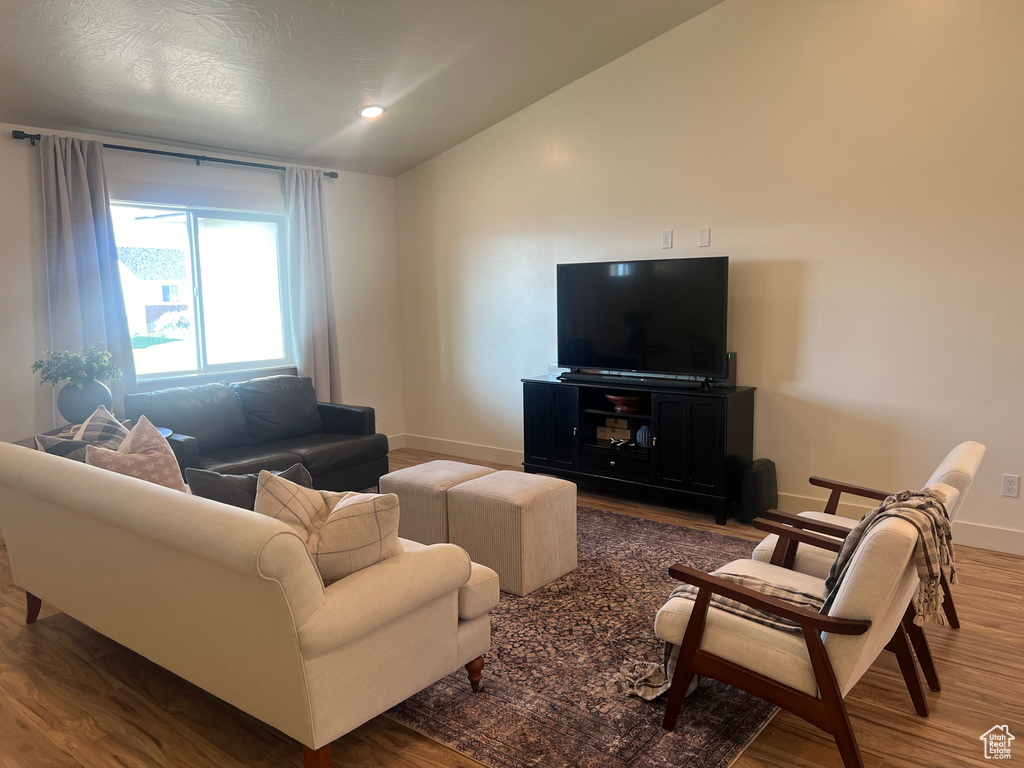 Living room featuring hardwood / wood-style flooring and lofted ceiling