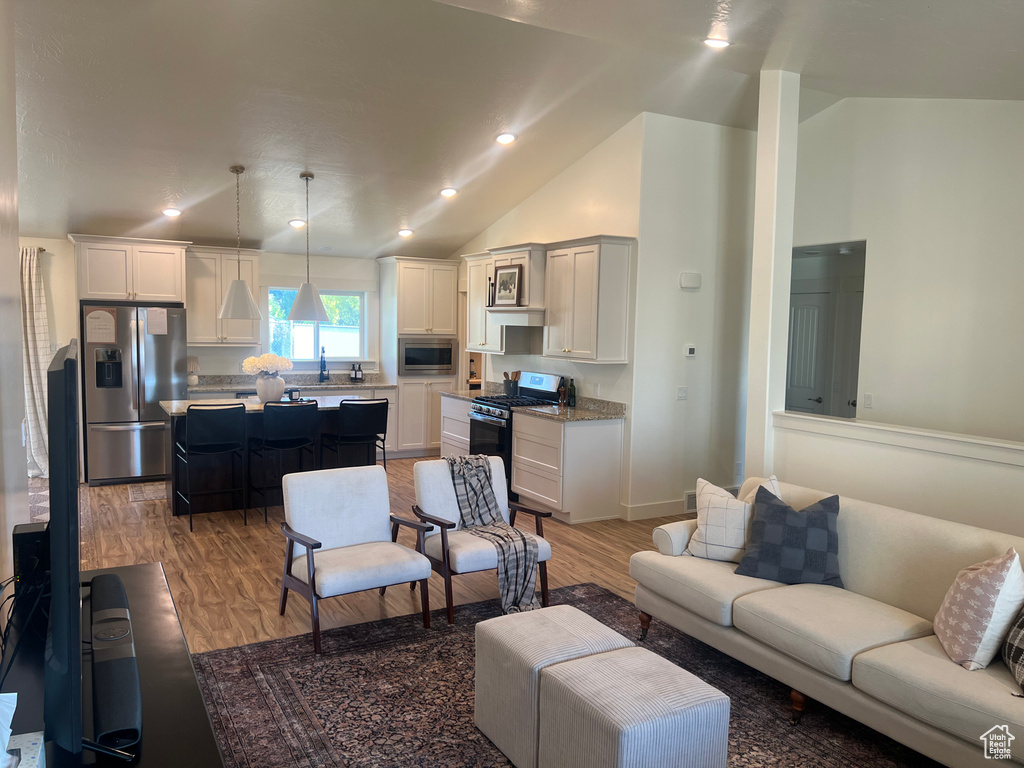 Living room with wood-type flooring and high vaulted ceiling