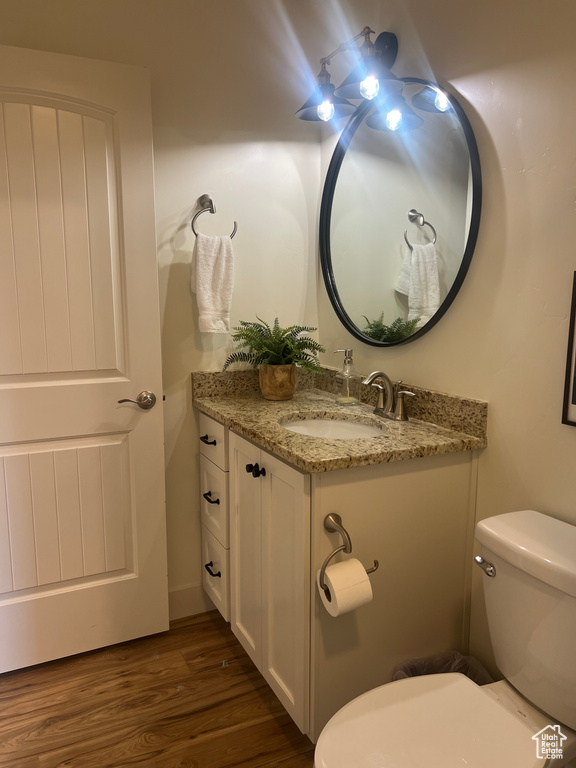 Bathroom featuring hardwood / wood-style flooring, toilet, and vanity