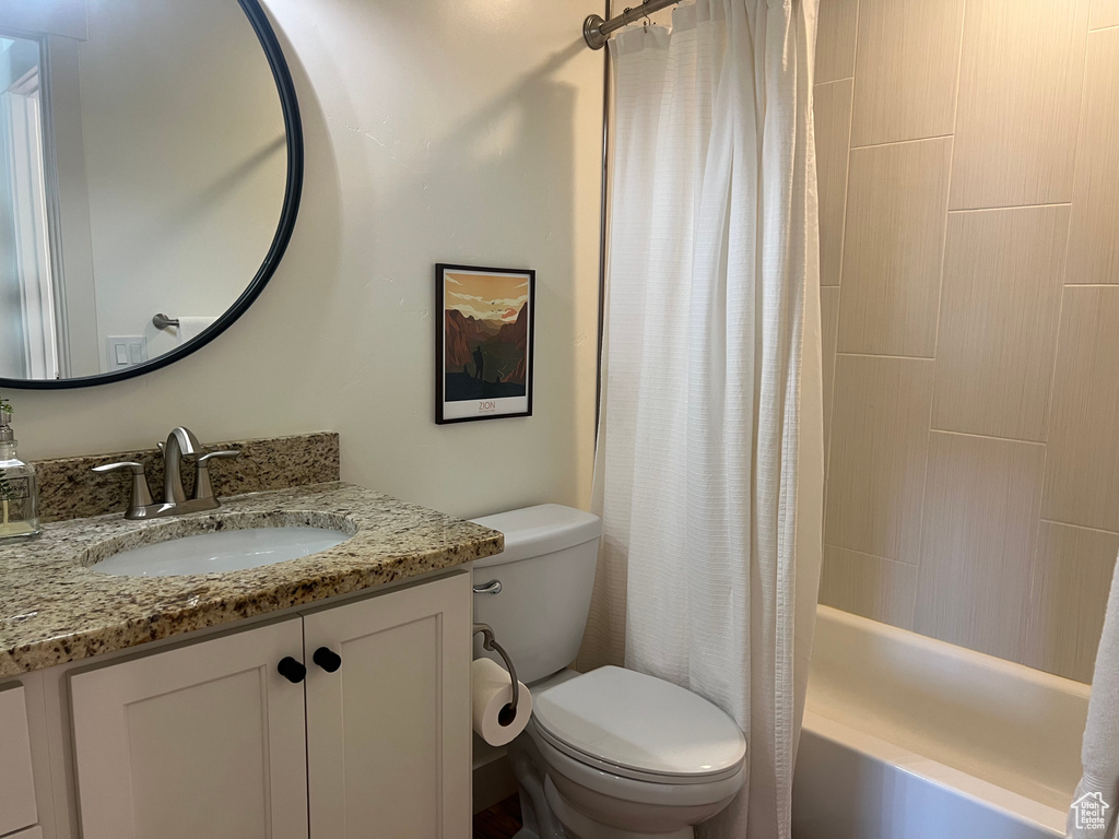 Full bathroom with vanity, toilet, and shower / bath combination with curtain