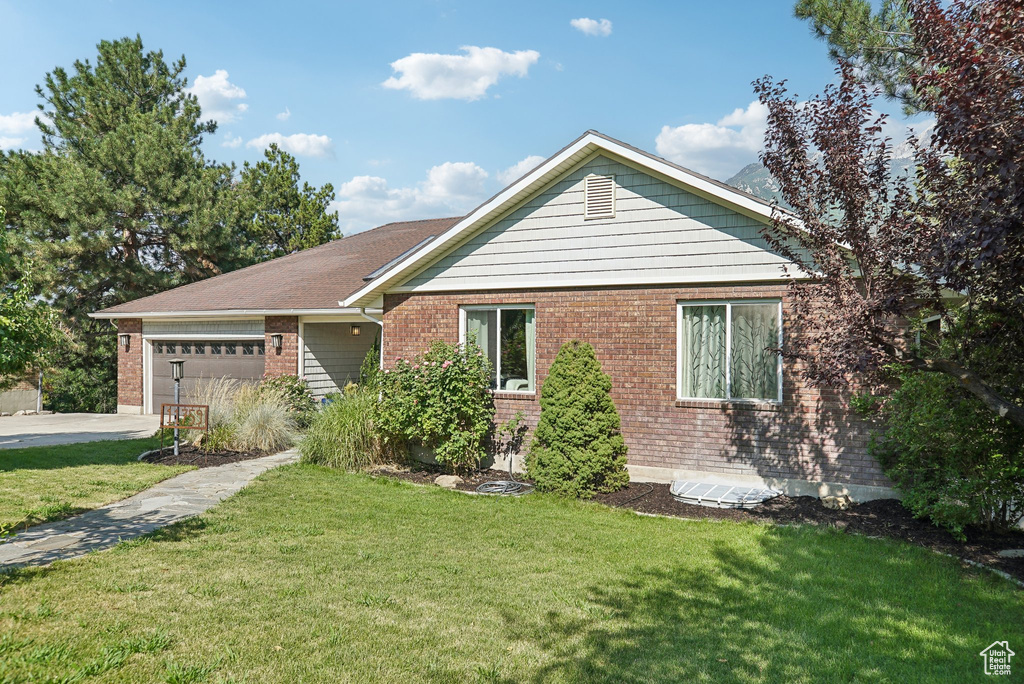 View of front of property with a garage and a front yard