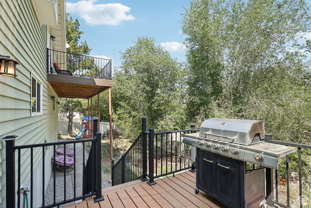 Wooden deck featuring a grill