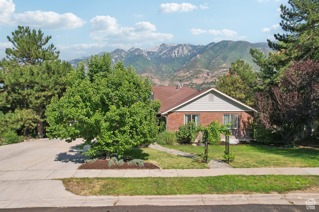 View of front of home with a mountain view and a front yard