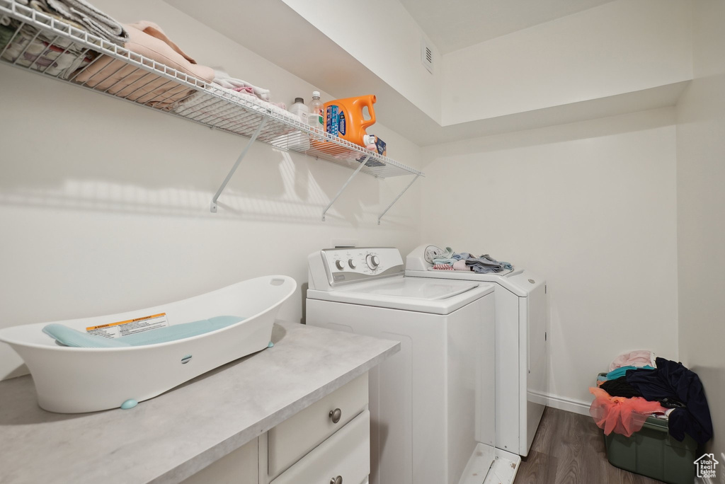 Laundry room featuring hardwood / wood-style flooring and separate washer and dryer